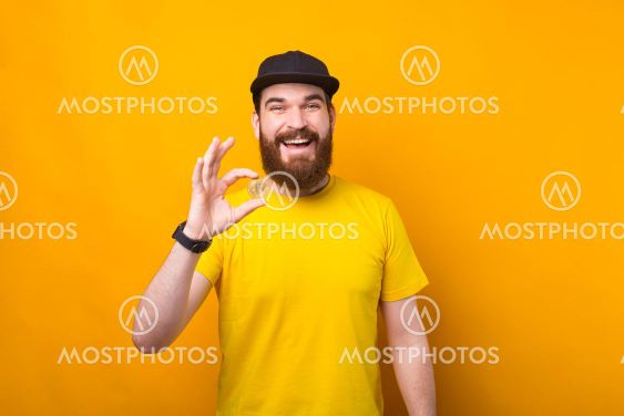 A young bearded man is holding excited a bitcoin looking...