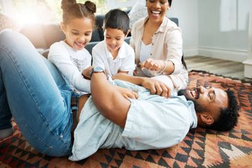 Parents, kids and happy in home with game, tickling fun...