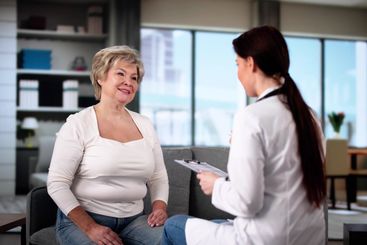 Doctor Talking To Elderly Patient At Home