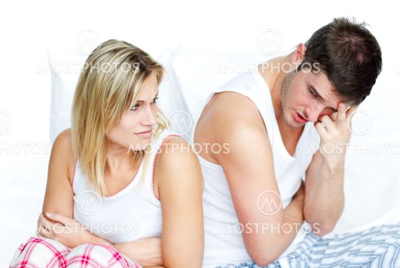 Angry couple having an argument in bed
