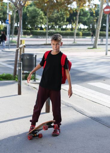 Handsome teenager standing with skateboard. Adolescent...