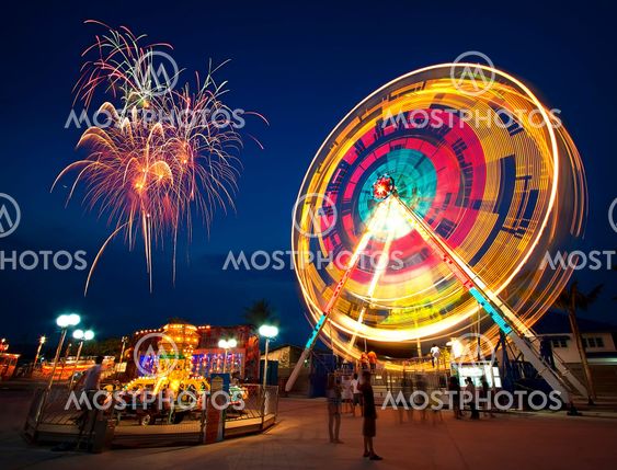 Amusement park at night - ferris wheel in motion and...