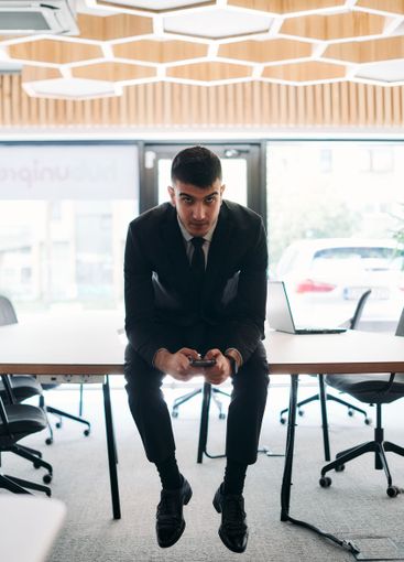 A businessman sitting on his desk, taking a moment to...