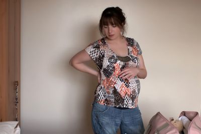 A pregnant young woman packing