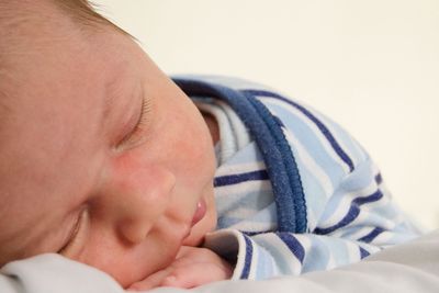 two weeks old newborn baby boy sleeping on white sheet