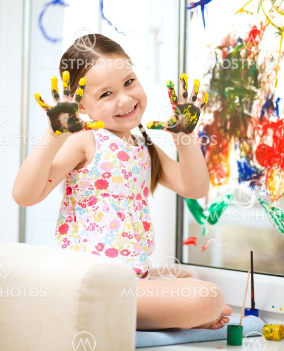 Portrait of a cute girl playing with paints