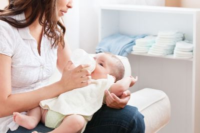 Close-up of a proud mother bottle-feeding her baby...