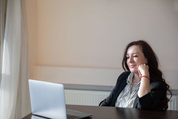 Business brunette woman at desk with laptop online in...