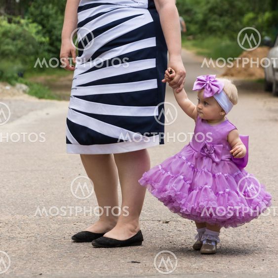 Beautiful little girl standing on the street in the model...
