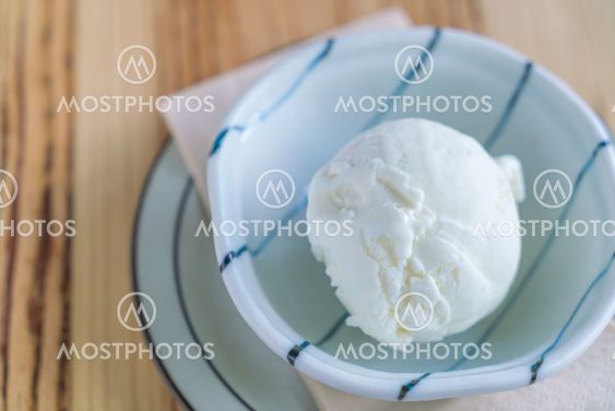 Milk ice cream in bowl on wood table .