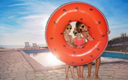 Kids ready for pool fun look through float ring in sunset...