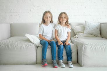 Cute little sister sitting together at home. Girl 5 and...