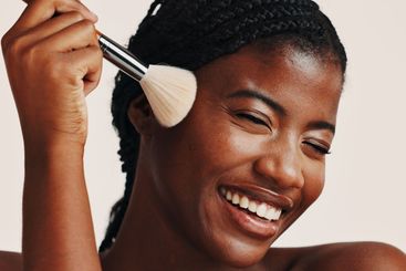 Brush, makeup and black woman in studio with beauty,...