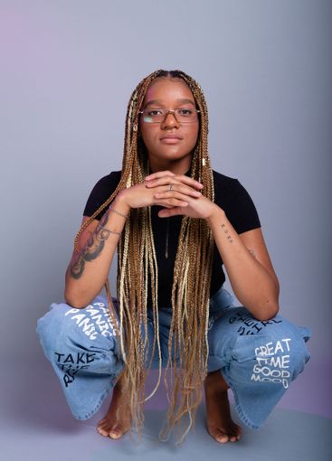 Brunette model with braids in her hair, wearing...