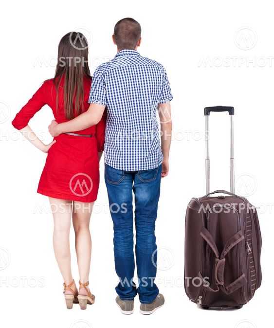 Back view of young couple traveling with suitcas .