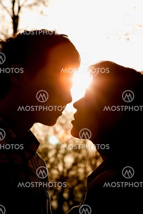 Profiles of romantic couple looking at each other on sunset back light