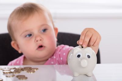 Baby Inserting Coin In Piggybank