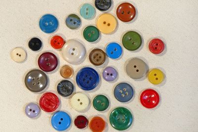 Multicoloured buttons on beige fabric.