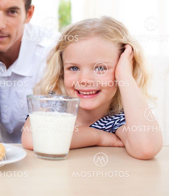 Smiling little girl drinking milk