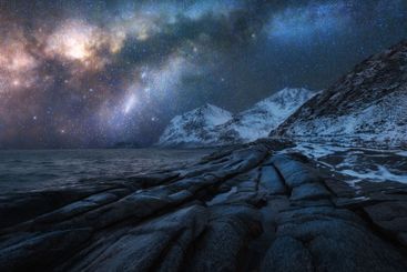 Night starry sky with Milky Way, snowy mountains,...