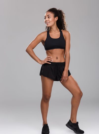 Full length portrait of a smiling afro american sportswoman