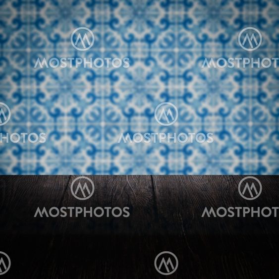 Wood table top and blur vintage ceramic tile pattern wall