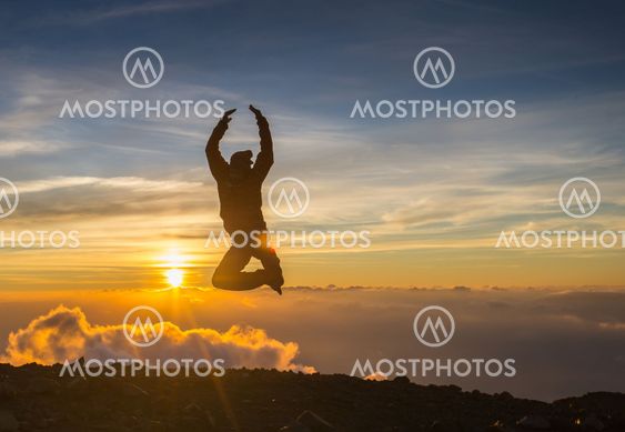 Man jump through the gap on sunset fiery background....