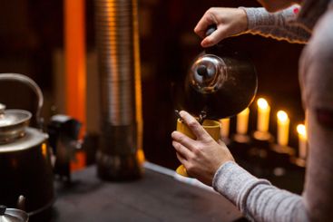 Close-up of woman pouring coffee to cup
