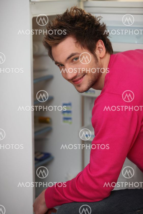 Young man looking in the fridge