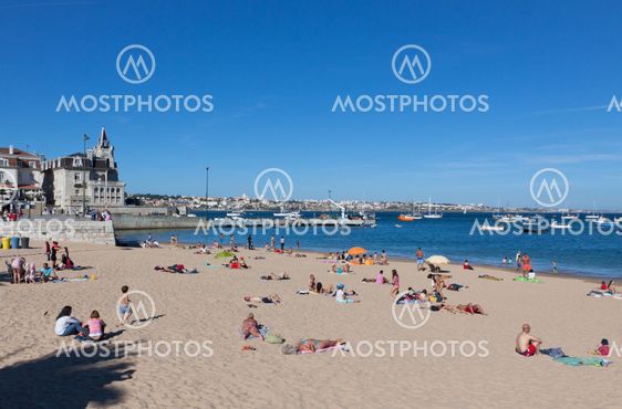 People sunbathing on the beach in Cascais, Portugal