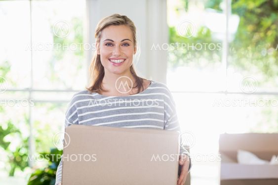 Portrait of young woman holding cardboard boxes