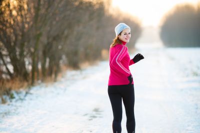 Winter running - Young woman running outdoors on a cold...