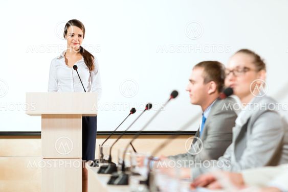 Business woman speaks into a microphone
