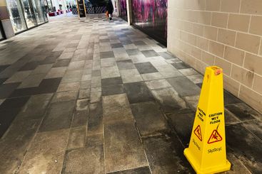 Indoor shopping mall corridor with caution sign on a...
