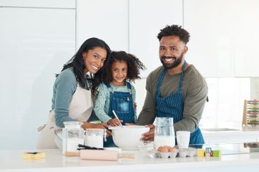 Parents, daughter and baking portrait in kitchen with...