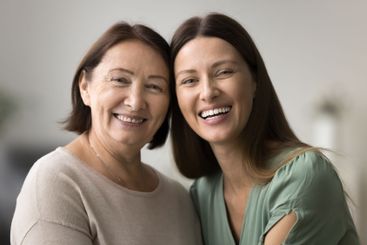 Two beautiful older and younger women posing for camera