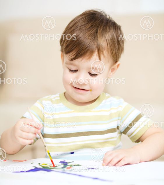 Little boy is playing with paints