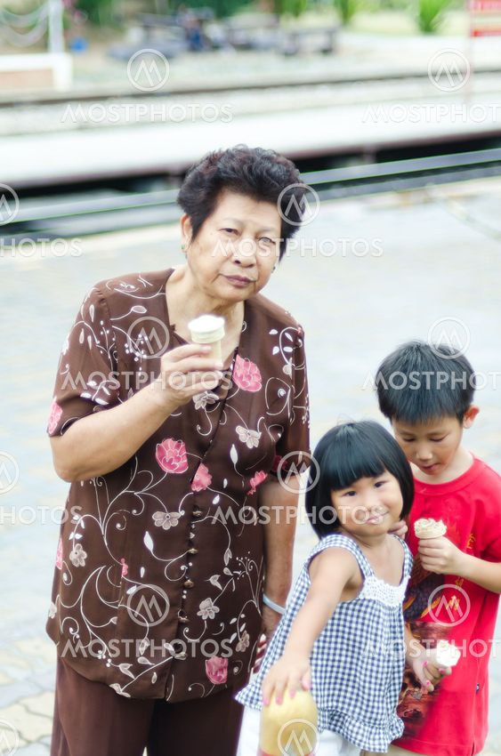 Happy Asian Grandmother with children and icecream, Hua Hin railway station