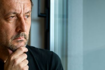 Serious caucasian mature adult male looking through...