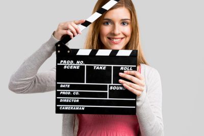 Beautiful girl holding clapboard