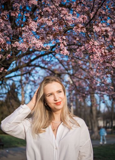 Woman with cherry flowers surrounded by blossoming trees...