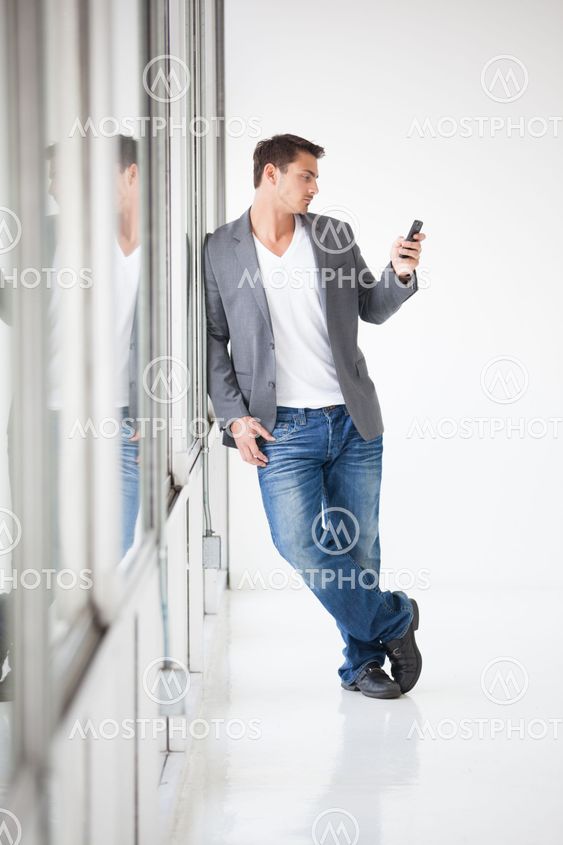 Attractive man standin and texting