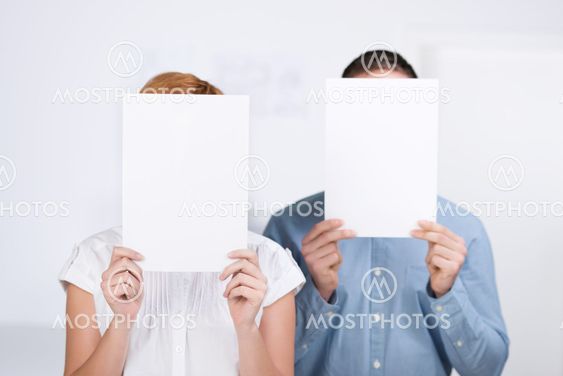 Businesspeople Holding Blank Paper In Front Of Their Faces