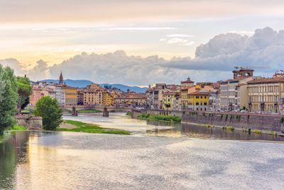 Daylight view to sunset above Arno river with reflections