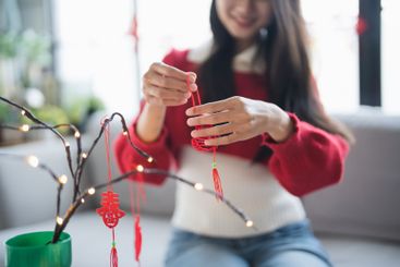 Asian Woman decorated house for Chinese New Year...