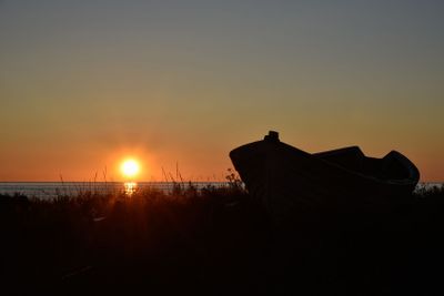 Afton vid havet, solnedgång med silhuett av fiskebåt