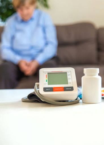 An old woman measures her blood pressure. Selective focus.