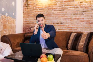 Happy entrepreneur working from home showing thumbs up...