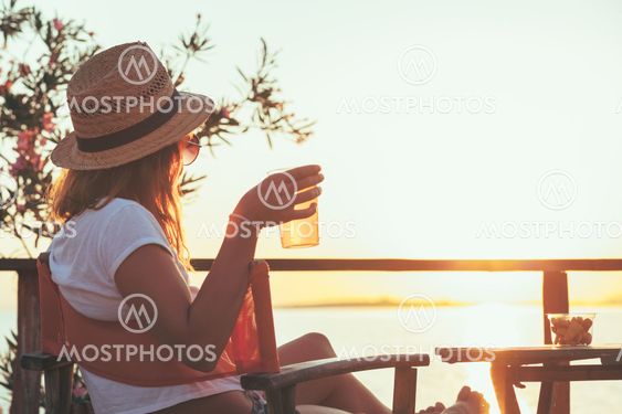 Young woman enjoying sunset at a beach bar