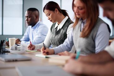 Studying In Classroom At Campus. Students Writing